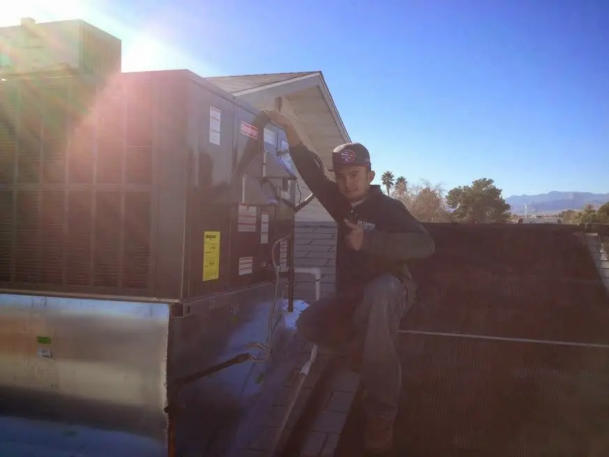 HVAC technician performing HVAC Inspection on a rooftop unit in Riverbank